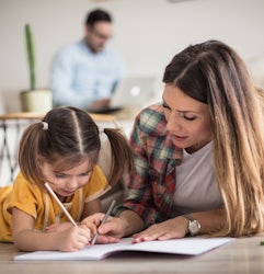 Mother and daughter drawing together Man in background on computer