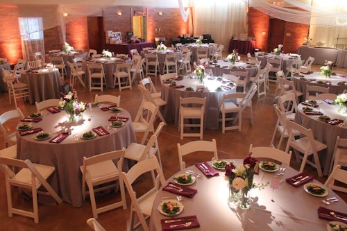 The interior of Harleys Haven Barn with tables dressed for wedding with flowers and dishes